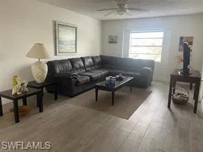 Living room with hardwood / wood-style flooring and ceiling fan