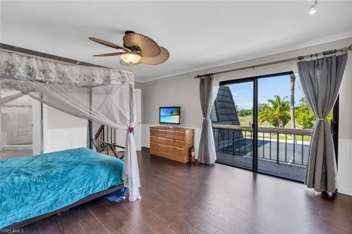 Bedroom featuring access to exterior, ornamental molding, wood finished floors, and a ceiling fan