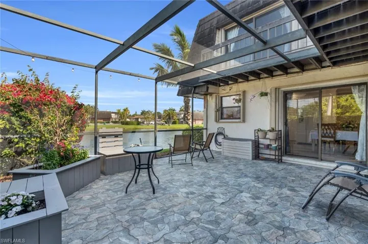 Patio / terrace with a patio area, a water view, and glass enclosure