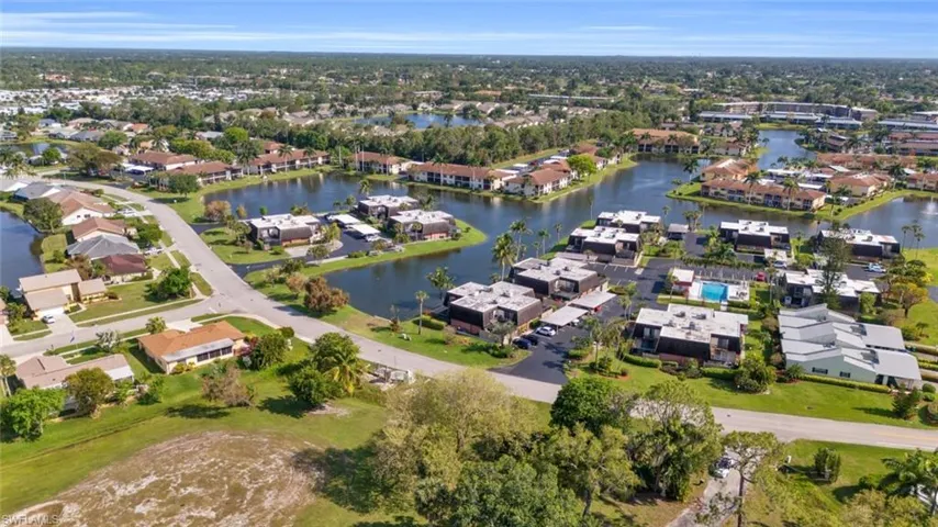 Aerial view of property and surrounding area with nearby suburban area and a nearby body of water