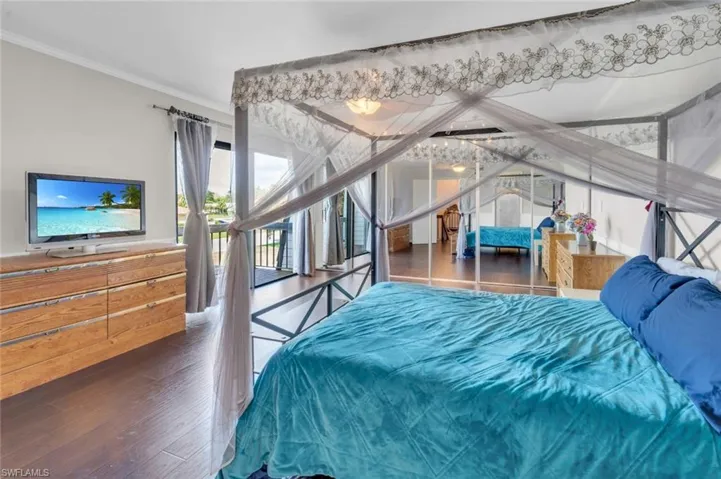 Bedroom featuring wood finished floors and crown molding
