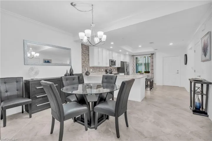 Dining area with ornamental molding and a notable chandelier