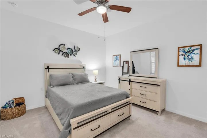 Carpeted bedroom featuring ceiling fan