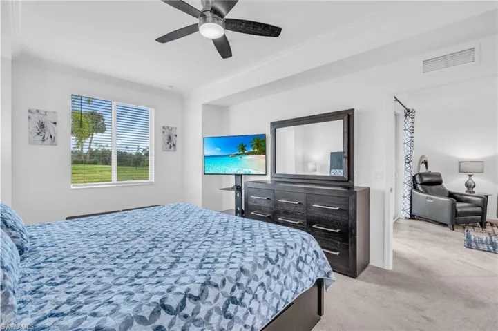 Carpeted bedroom featuring crown molding and ceiling fan