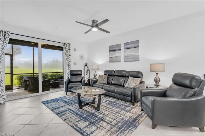 Tiled living room featuring ornamental molding and ceiling fan