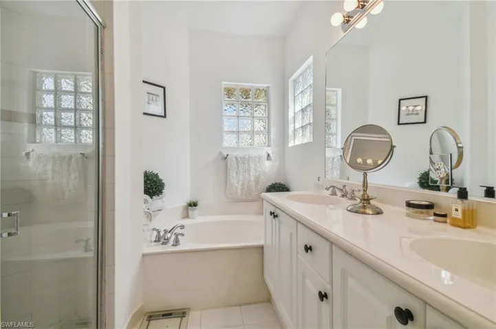 1st Floor Bedroom's Private Bathroom featuring tile patterned flooring, a healthy amount of sunlight, vanity, and plus walk in shower