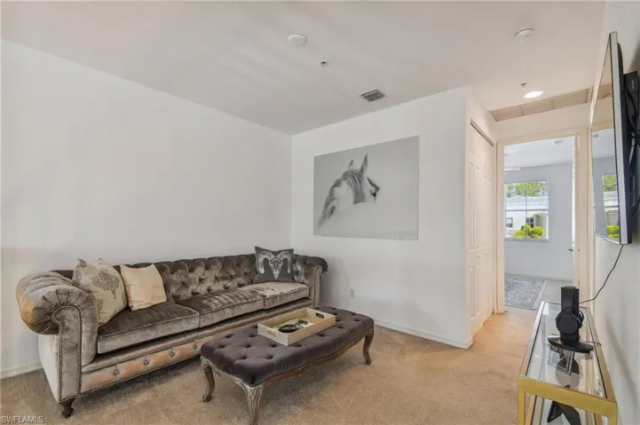 Loft featuring light colored carpet
