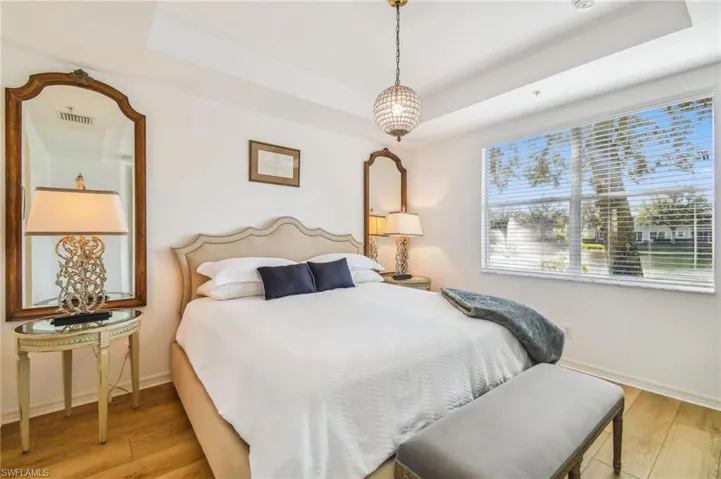 1st Floor Bedroom with a raised ceiling and light hardwood / wood-style floors