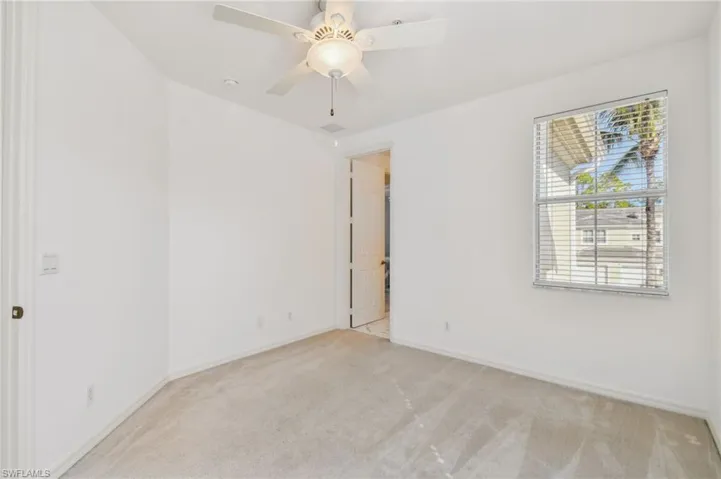 Carpeted spare room with ceiling fan