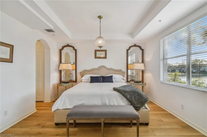 1st floor Bedroom with a tray ceiling and light hardwood / wood-style floors