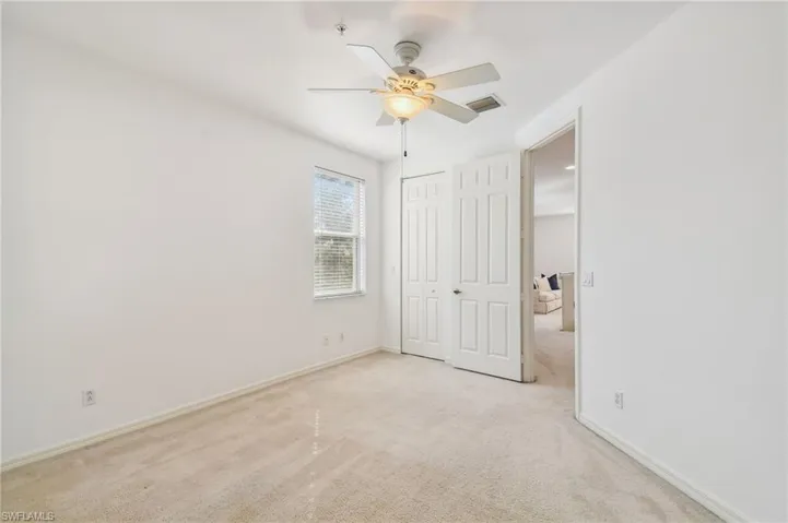 Unfurnished bedroom with ceiling fan and light carpet