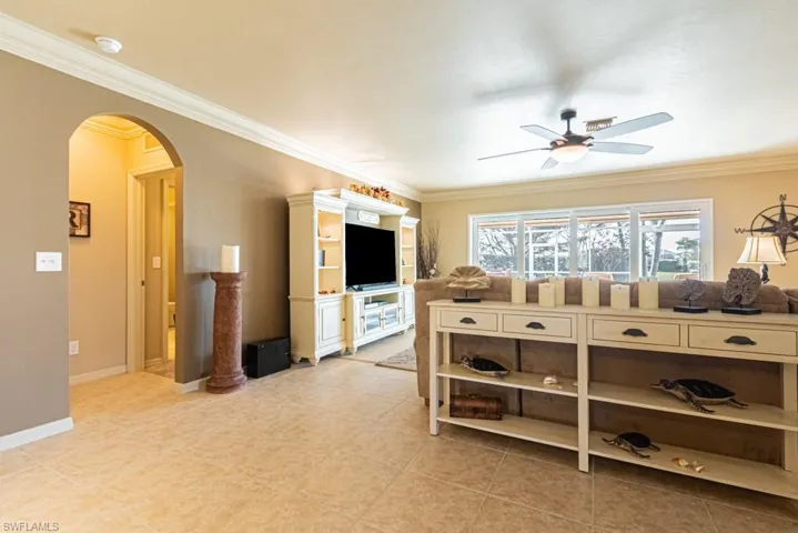 Living room with ceiling fan and crown molding