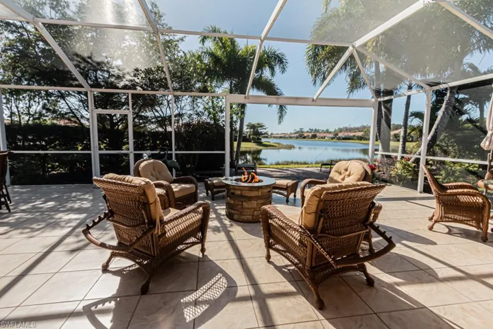 View of patio / terrace featuring a lanai, a water view, and a fire pit