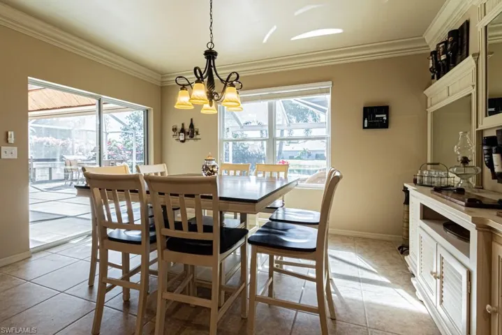Dining room with a wealth of natural light, light tile patterned flooring, and a notable chandelier