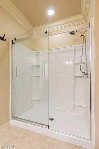 Bathroom featuring ornamental molding, walk in shower, and tile patterned floors