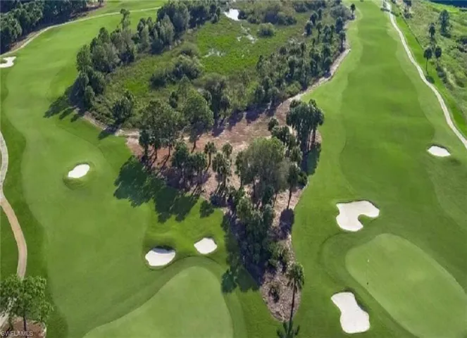 View of property location with a local golf course and a tree filled landscape