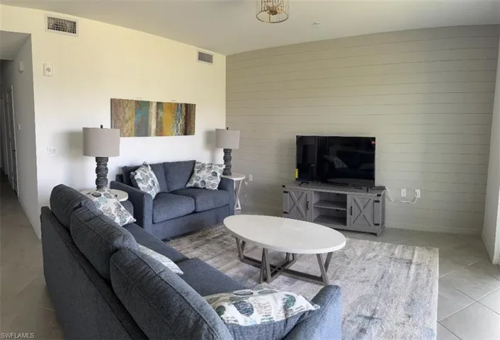 Living area with light tile patterned floors and wooden walls