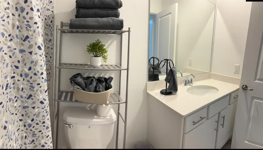 Bathroom featuring curtained shower and vanity