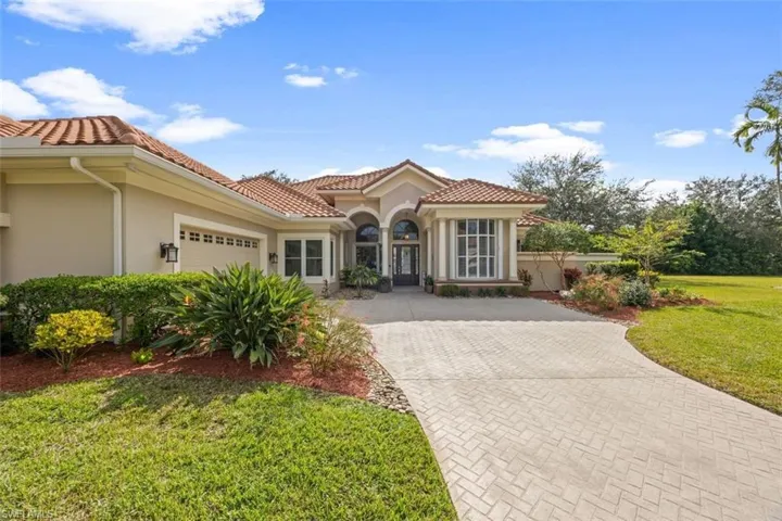 Mediterranean / spanish-style house with a front yard and a garage