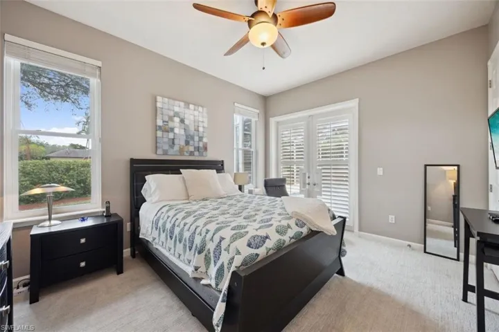 Bedroom with ceiling fan and light carpet