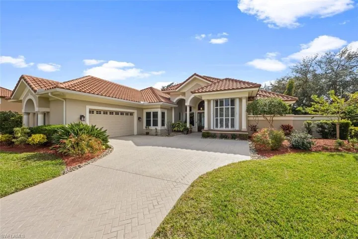 Mediterranean / spanish-style home with a front yard and a garage