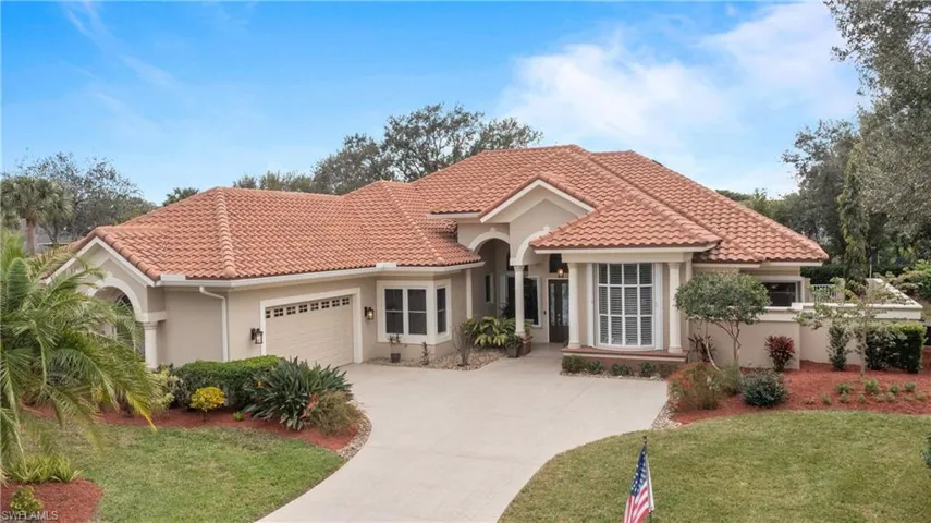 Mediterranean / spanish-style house featuring a front lawn and a garage