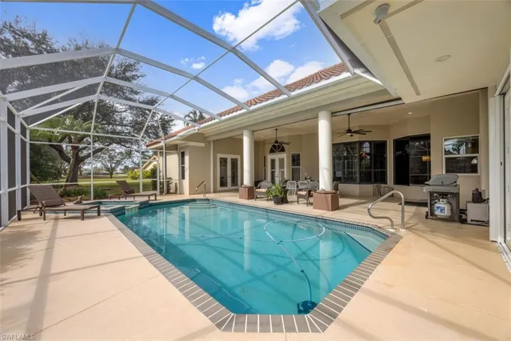 View of swimming pool featuring french doors, a lanai, ceiling fan, and a patio area