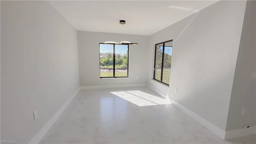 Unfurnished room featuring a notable chandelier and light tile patterned flooring