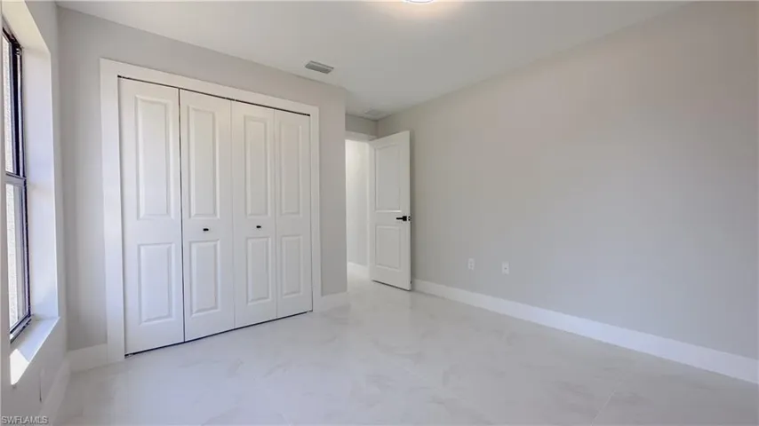 Unfurnished bedroom with light tile patterned flooring and a closet