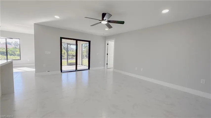 Tiled spare room with ceiling fan and a healthy amount of sunlight