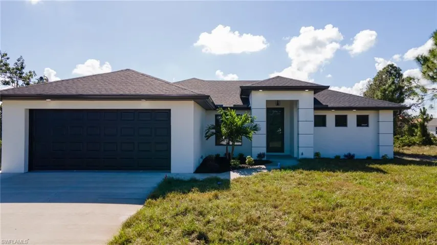View of front of home featuring a garage and a front yard