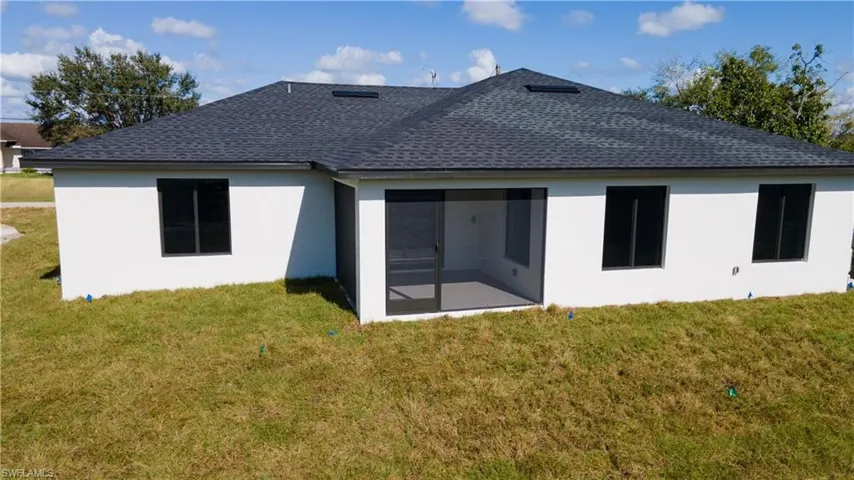 Rear view of property with a yard and a sunroom