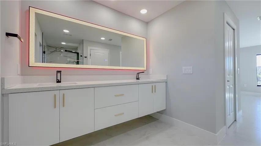 Bathroom featuring tile patterned flooring, vanity, and a shower with shower door