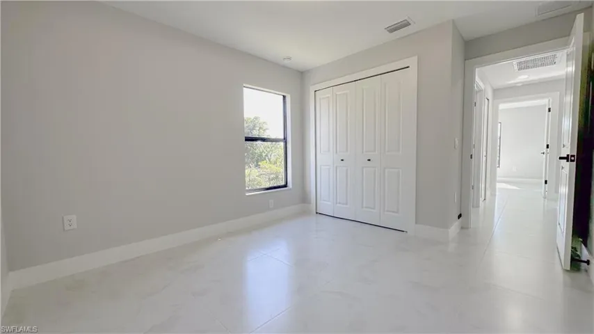 Unfurnished bedroom featuring light tile patterned floors and a closet