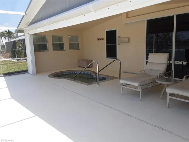 View of patio featuring an in-ground hot tub and a lanai