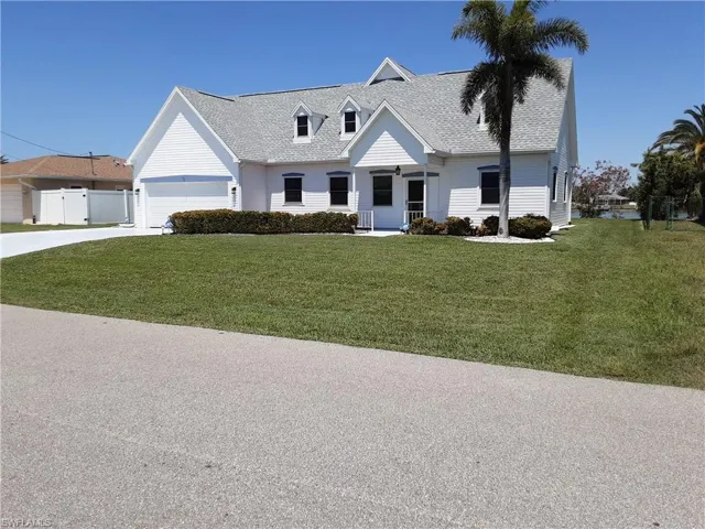 Cape cod home with a front yard, concrete driveway, and roof with shingles
