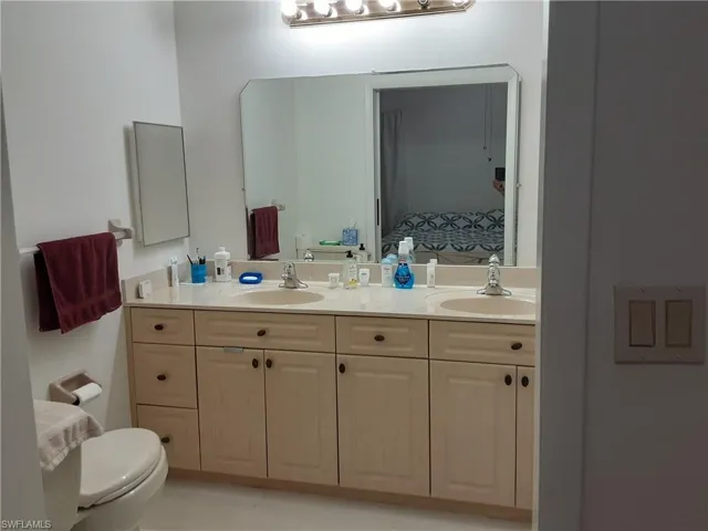 Bathroom featuring toilet and double vanity