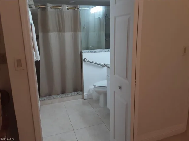 Full bath featuring a shower stall and light tile patterned floors