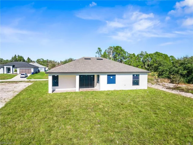 Back of property featuring a yard