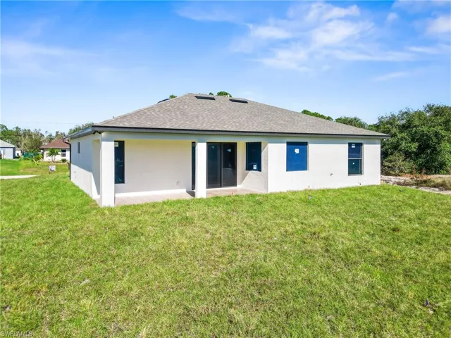Back of house with a yard and a patio area