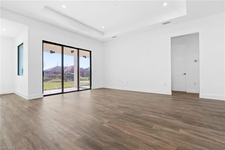 Empty room with a raised ceiling and hardwood / wood-style floors