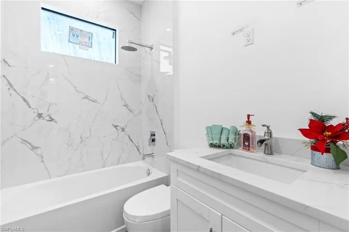 Full bathroom featuring vanity, toilet, and tiled shower / bath