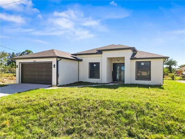 View of front of house featuring a front yard, french doors, and a garage