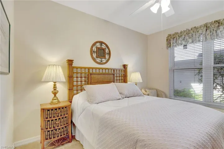 Bedroom with light carpet, baseboards, and ceiling fan