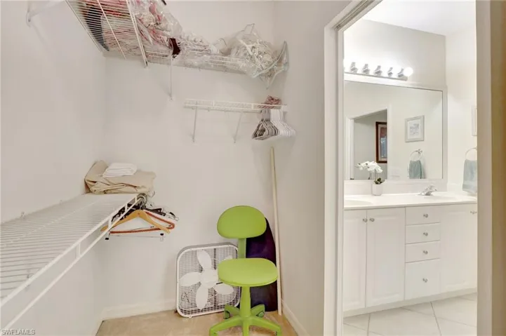 Walk in closet featuring light tile patterned floors and a sink