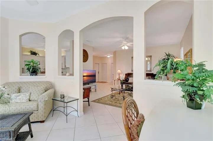 Living area with light tile patterned flooring and ceiling fan