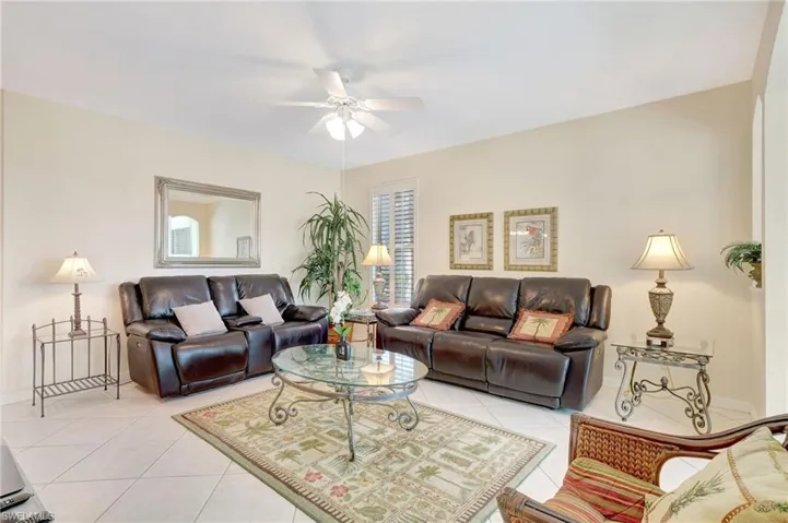 Living area featuring light tile patterned flooring, baseboards, and ceiling fan