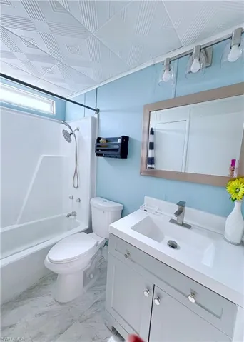 Full bathroom featuring vanity, shower / washtub combination, and light marble finish flooring