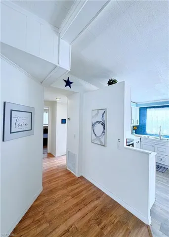 Hall featuring light wood finished floors and a textured ceiling