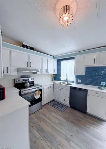 Kitchen with stainless steel electric range, white cabinets, black dishwasher, a textured ceiling, and light wood finished floors